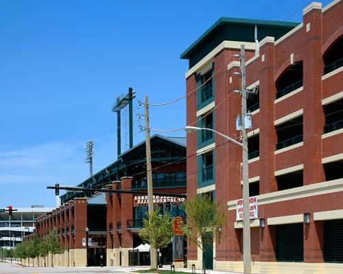 Exterior photo of Jacksonville 市政 Garages. Photo is a street view of the arena and sports parking garage. Red brick with green trim and accents.